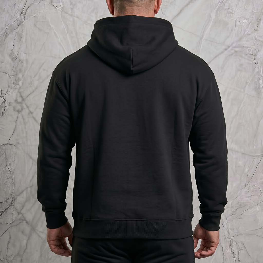 Man i en lyxig fotostudio som bär en svart herr och dam oversized hoodie tagen bakifrån.